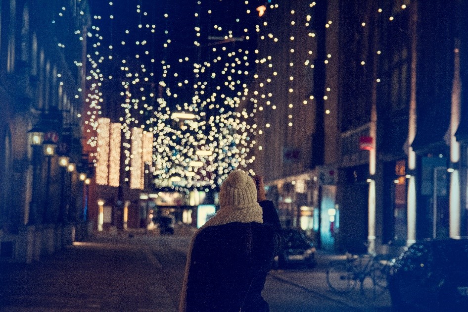 a woman walking down a street on her way to a christmas party