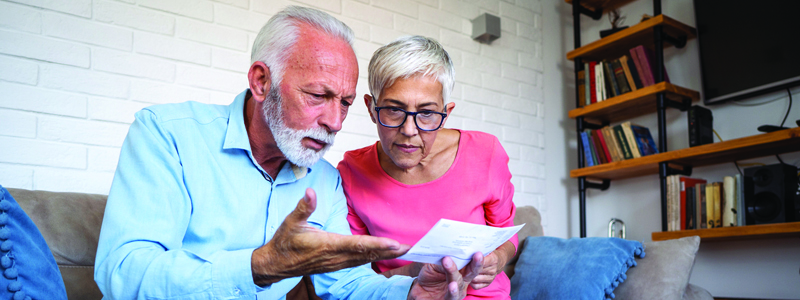 elderly couple looking at the confidential paper confusingly