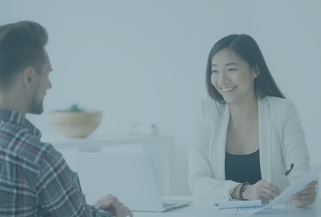 smiling female financial advisor explaining about employee retirement plan to her client while holding pen and paper