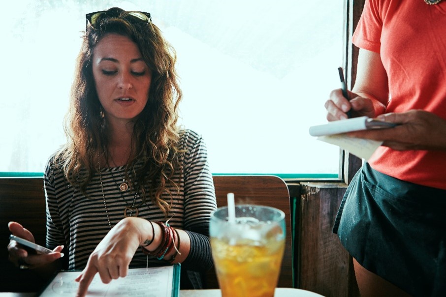 a woman ordering off a menu at a restaurant