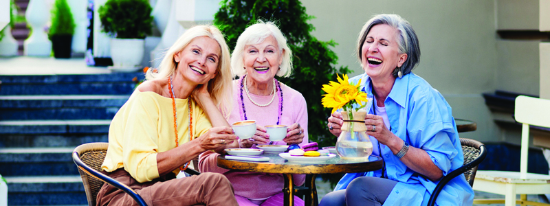three women drinking tea and laughing