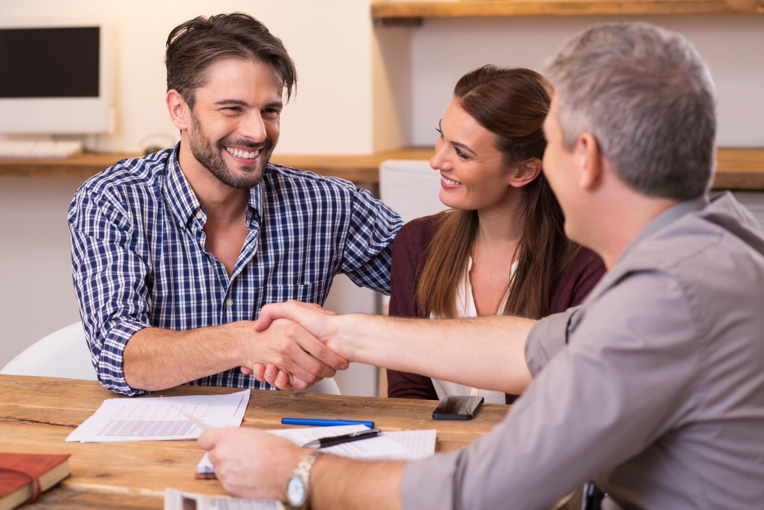 financial planner shaking hands with a man over paperwork